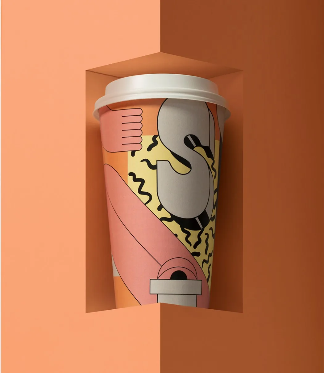 Kaffeebecher mit gemustertem Becherhalter in einer orangen Nische