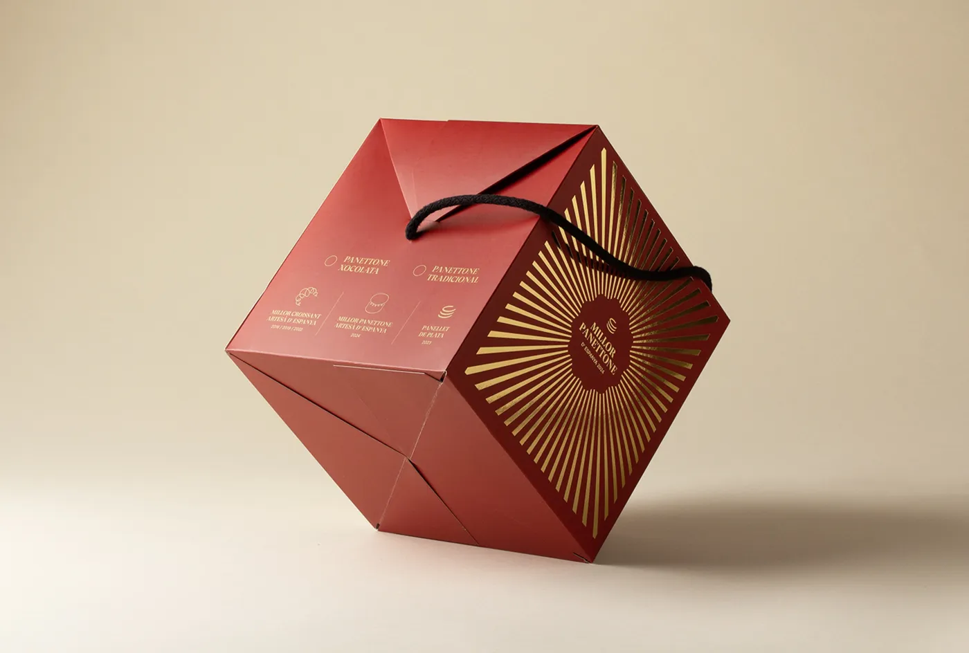 Rote, geometrische Geschenkschachtel mit goldenem Strahlenmuster
