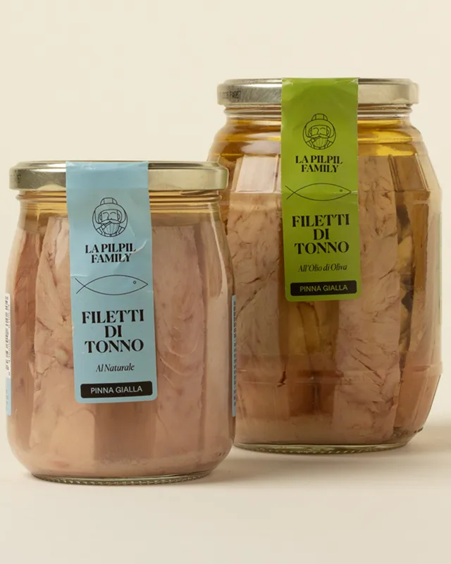Zwei Gläser mit Thunfischfilets und senkrechten Etiketten in Blau und Grün